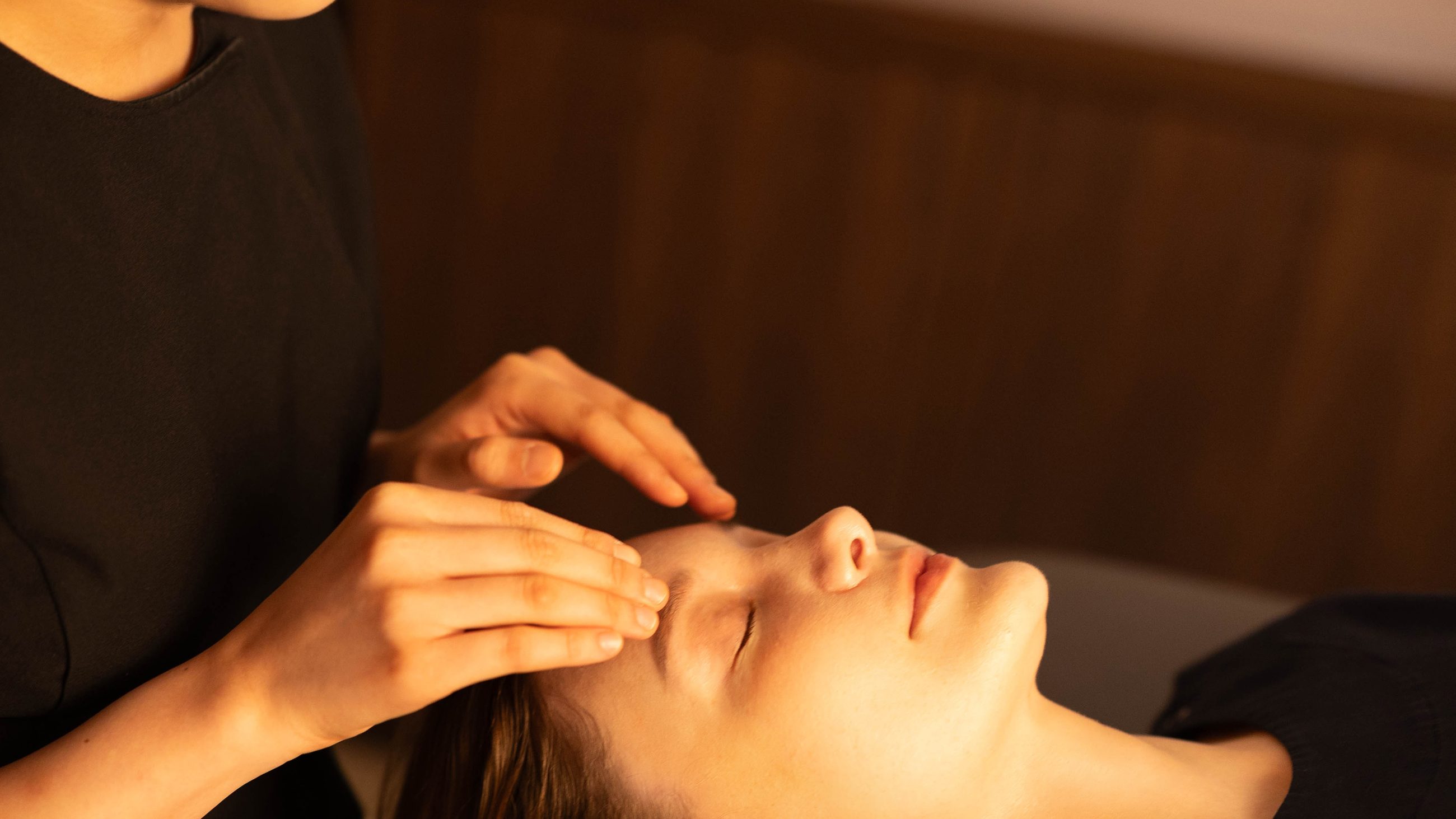 Hands working across the forehead during a facial treatment at Face Jion